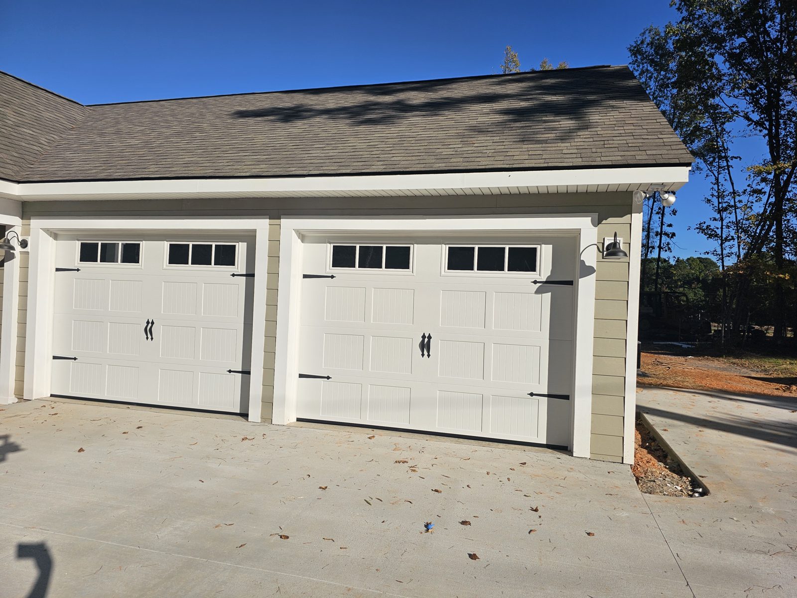Pair of white carriage-style garage doors installed by Premier Access Solutions