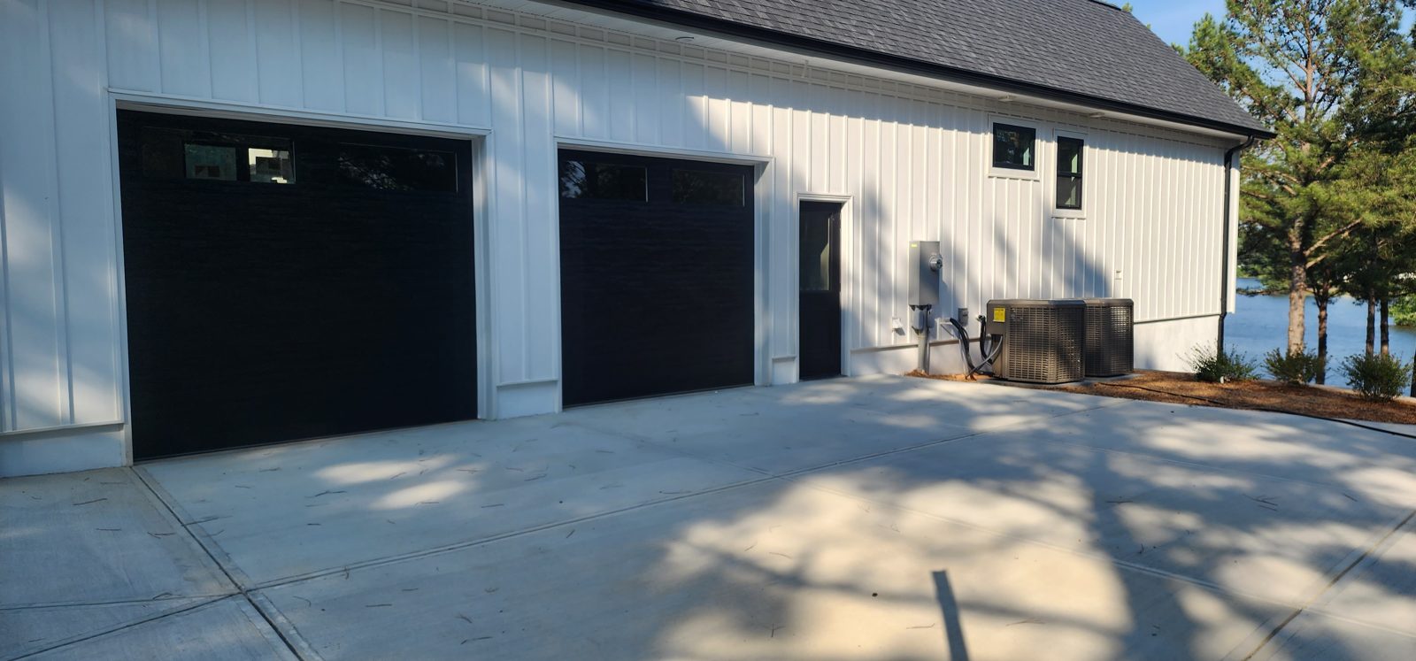 Dark garage door installation on a stone-front building by Premier Access Solutions
