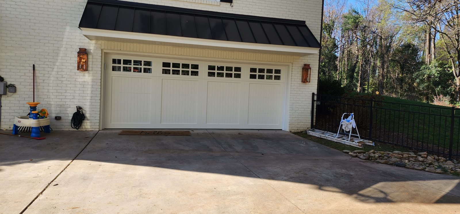 Tan double garage door installation by Premier Access Solutions