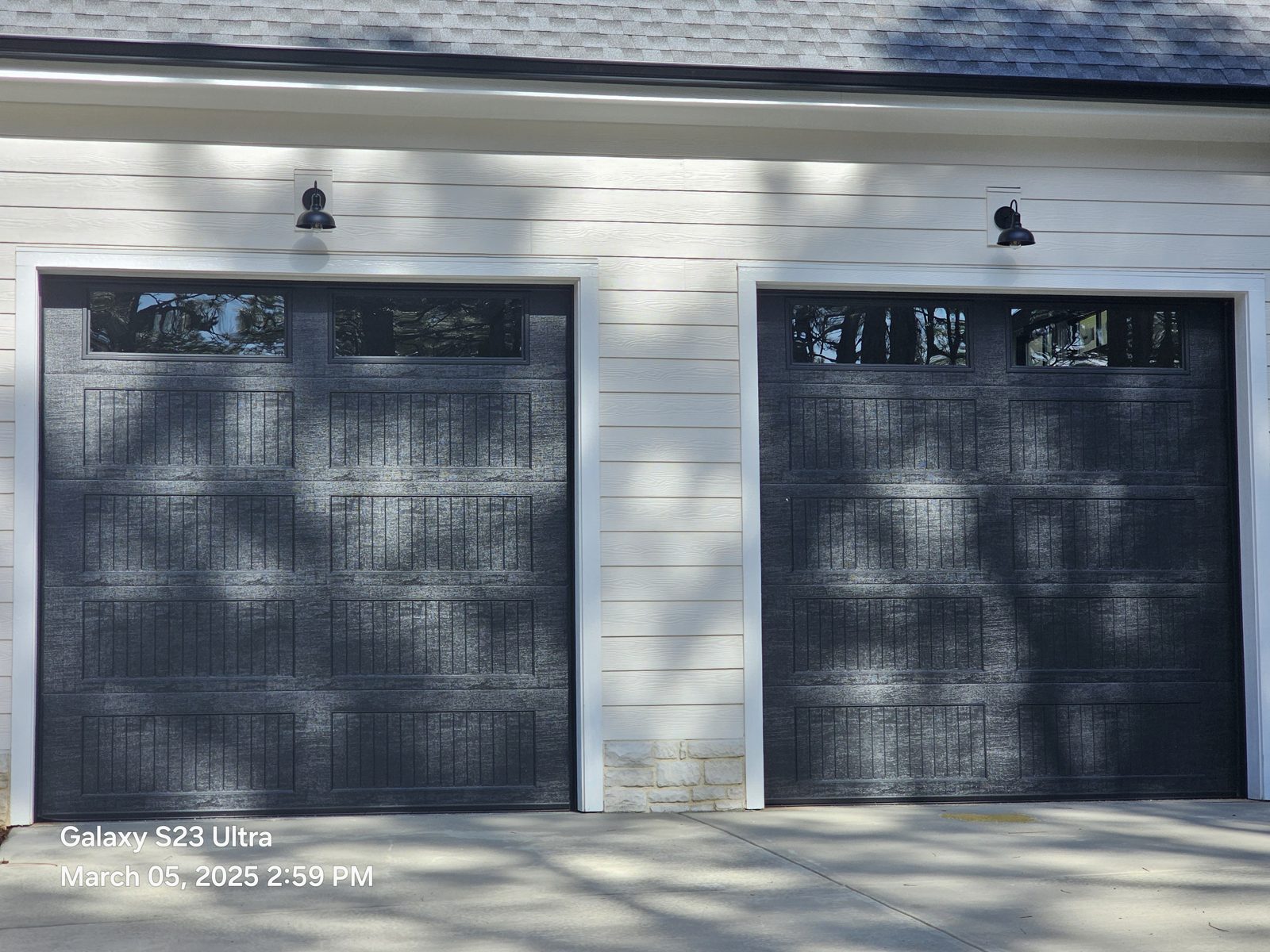 Pair of dark carriage-style garage doors installed by Premier Access Solutions
